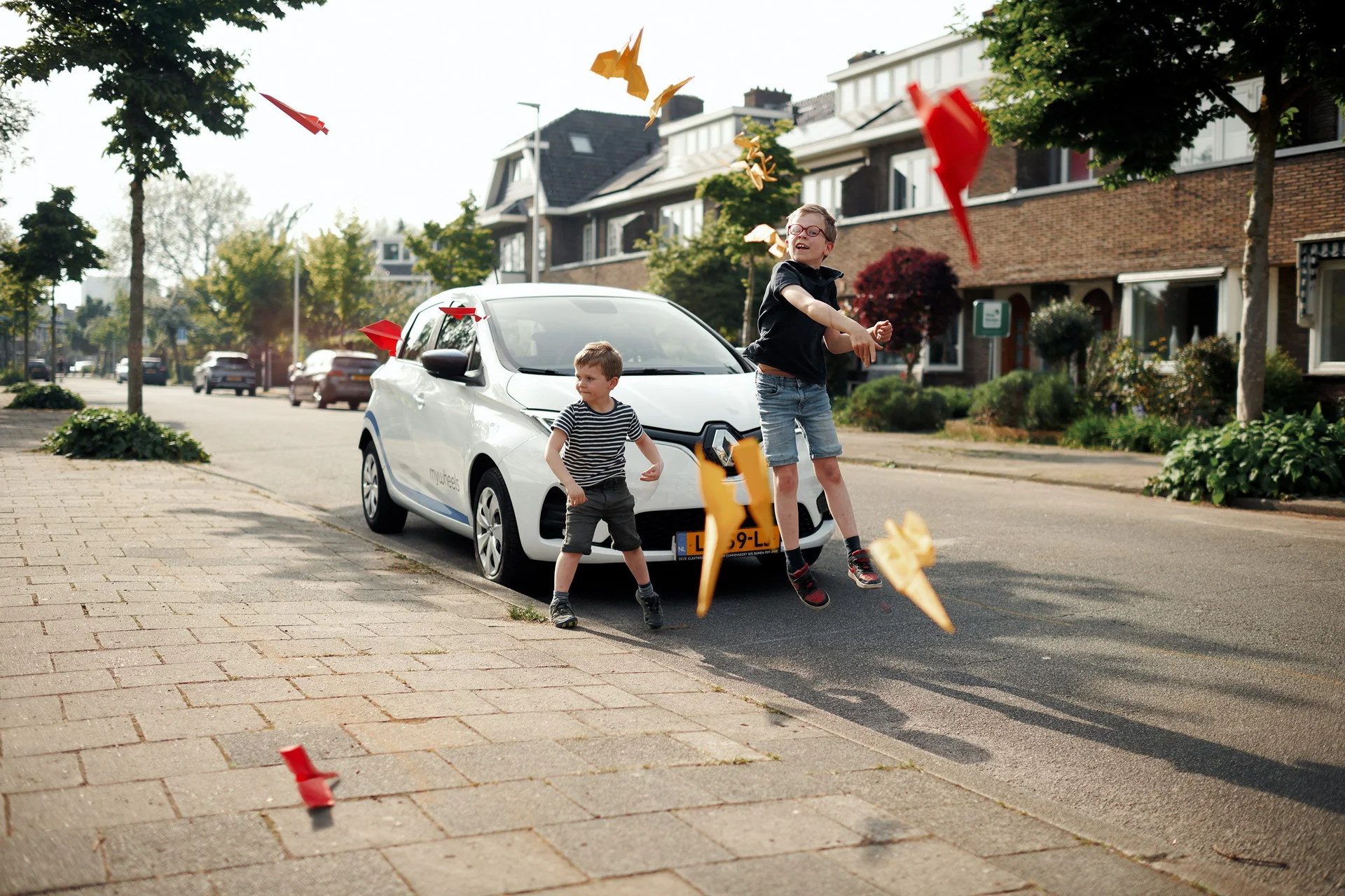 Kinderen spelen op straat voor een MyWheels-auto en besparen met een Plus of Pro abonnement