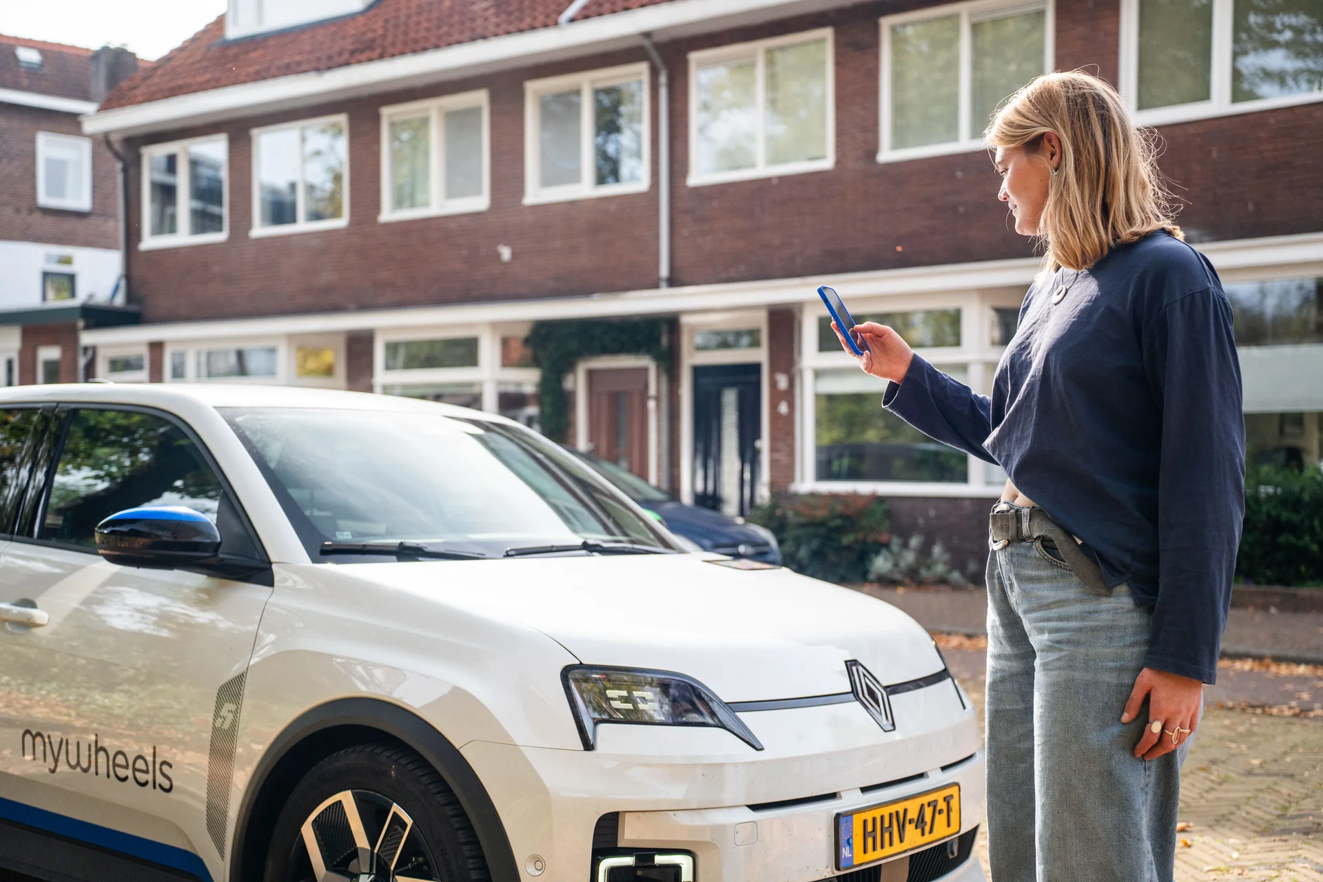 Vrouw staat naast MyWheels auto