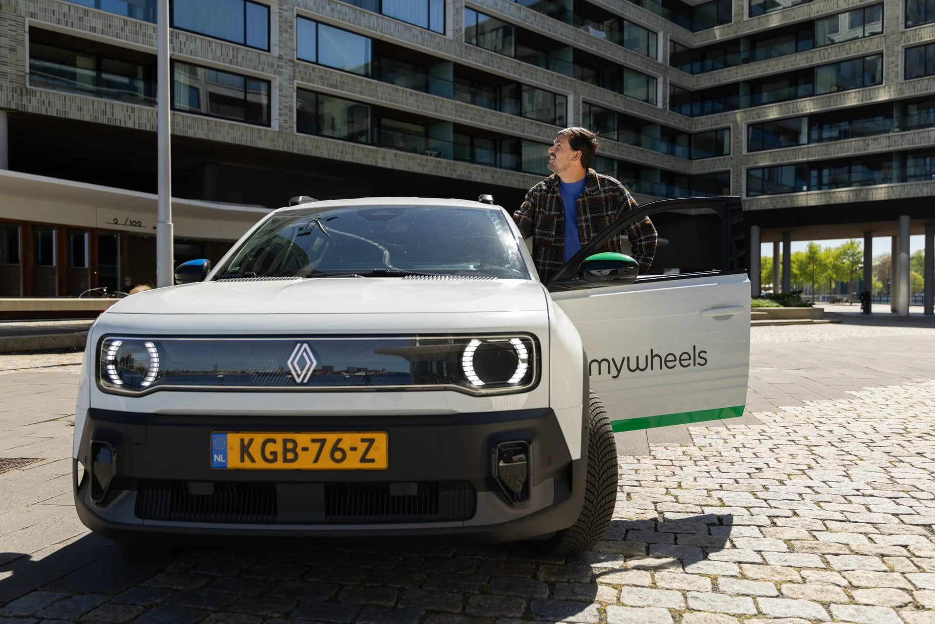 Man staat naast MyWheels auto