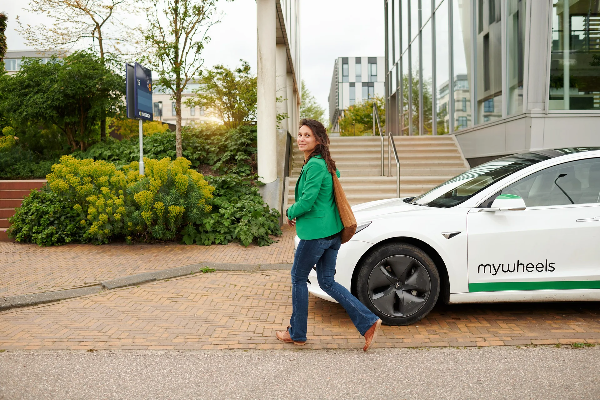 ZZP'er staand in de deuropening van zijn MyWheels deelauto.