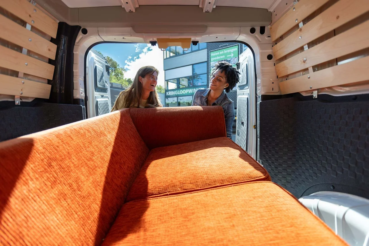 Vrouwen laden bank in bestelbus