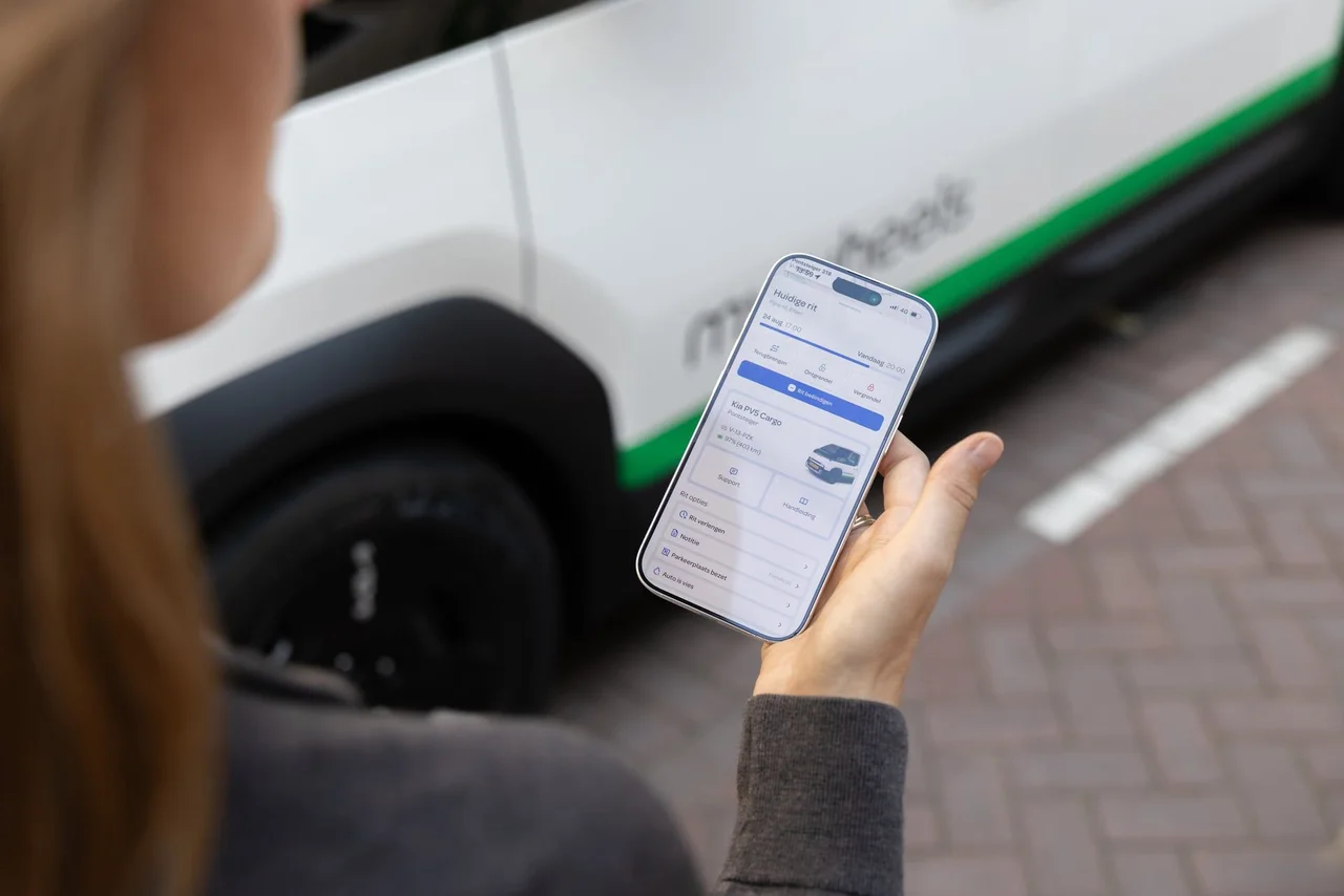 Vrouw kijkt naar MyWheels app op telefoon