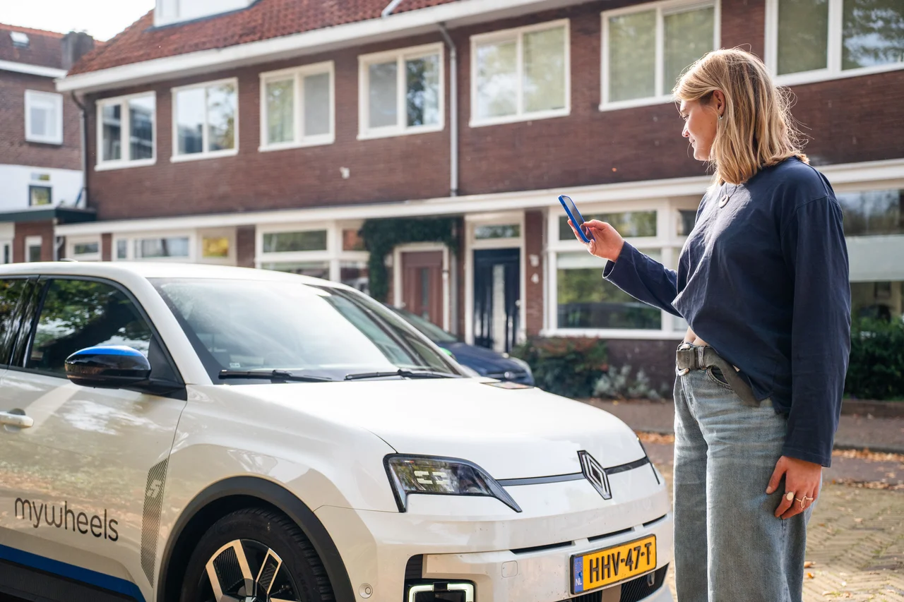 Vrouw opent MyWheels auto met telefoon