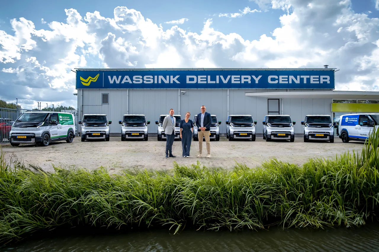 Drie personen staan voor negen MyWheels busjes