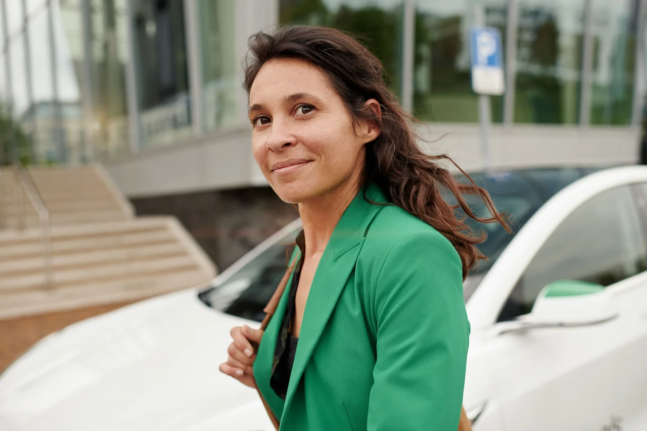 MyWheels ZZP freelancer dame loopt voor een Tesla model3 van MyWheels